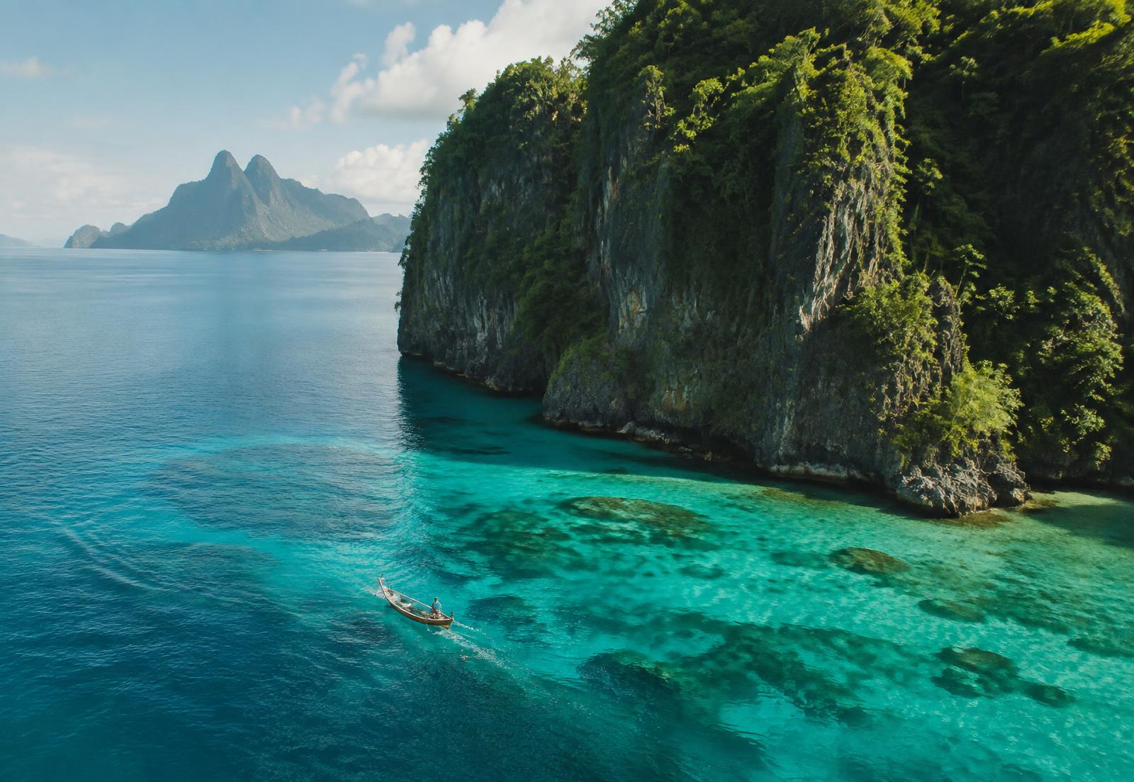 Small boat crossing clear water in French Polynesia